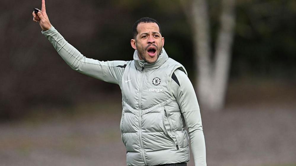 Liam Rosenior points to the sky while delivering instructions to his players during Chelsea training