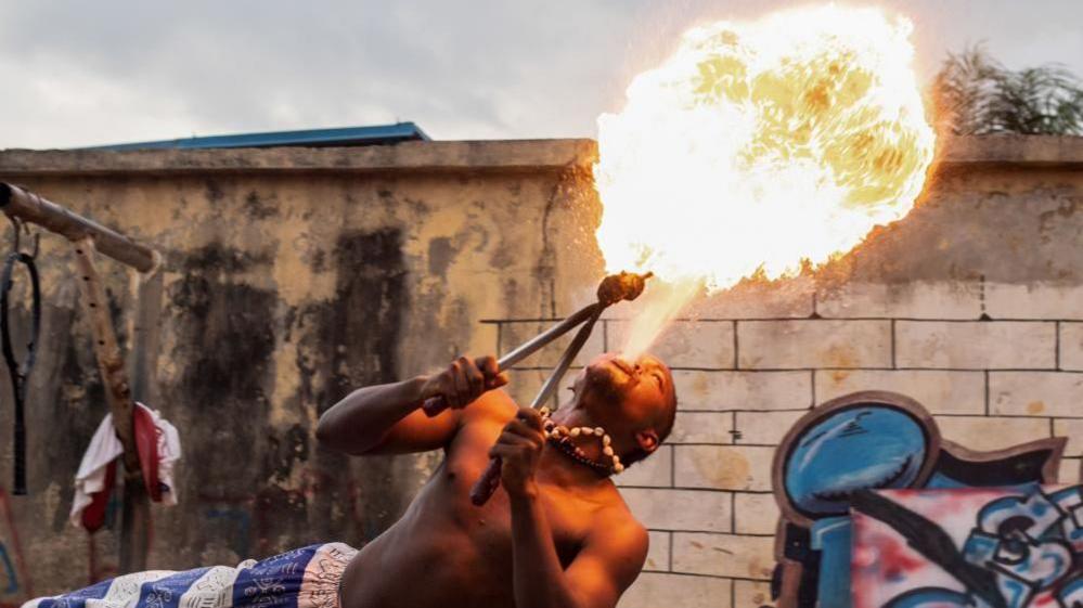 A fire breather performs during a slum party in Oworonshoki district of Lagos, Nigeria, 24 September, 2024