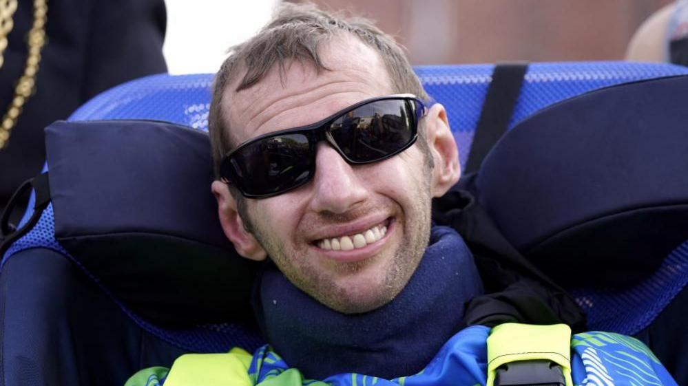 Rob Burrow is smiling and wearing sunglasses at the 2024 Rob Burrow Leeds Marathon