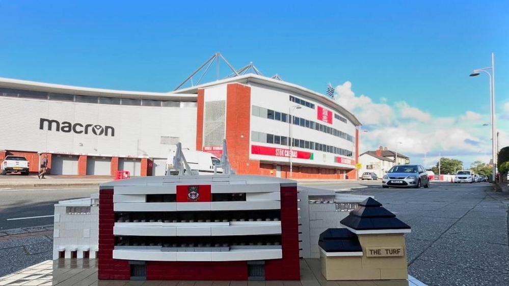 A Lego model of Racecourse Ground and nearby pub, The Turf, sat in front of the actual ground 