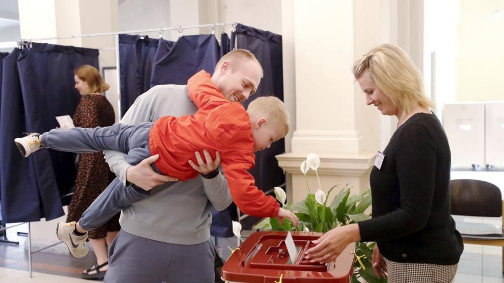 A boy casts a ballot during the European elections in Riga, Latvia, 08 June 2024