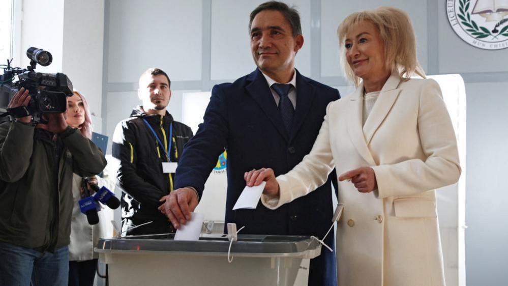 Moldova's presidential candidate Alexandr Stoianoglo and his wife Tvetana Kurdova cast ballots at a polling station during the second round of the presidential election in Chisinau, Moldova November 3, 2024