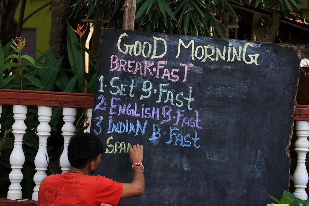 Man writing a menu on a blackboard