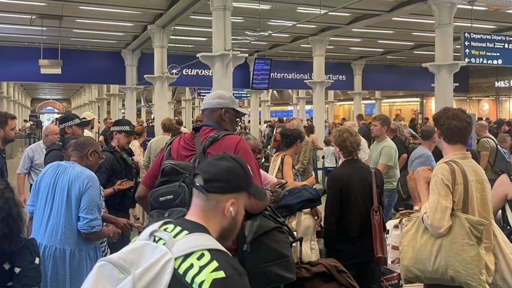Passengers queue at the Eurostar terminal at London's St Pancras International railway station