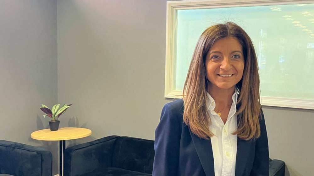 Cristina Taboada-Naya - Woman with long brown hair wearing a blue jacket