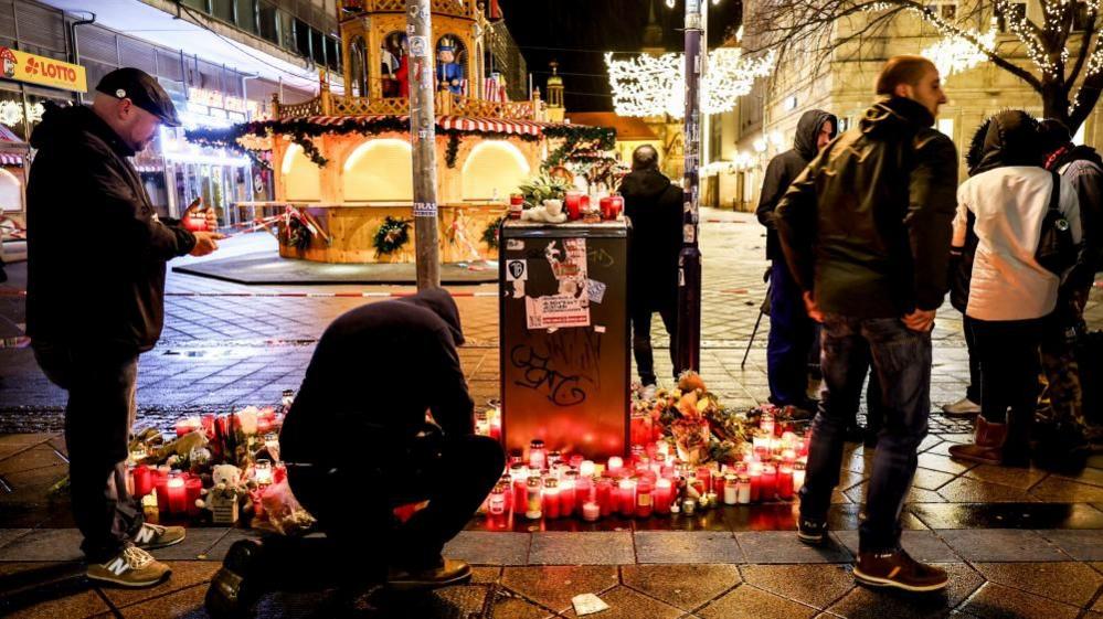 Flowers and candles next to the Christmas market in Magdeburg, Germany, 21 December 2024.