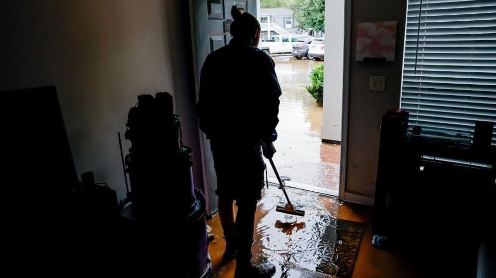 Peachtree Park Apartments resident Andrea Palese begins to clean up