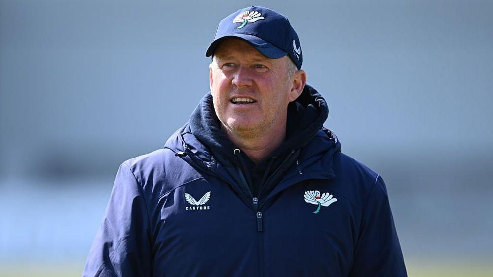 Anthony McGrath looks into the distance at training in a Yorkshire-branded coat and cap