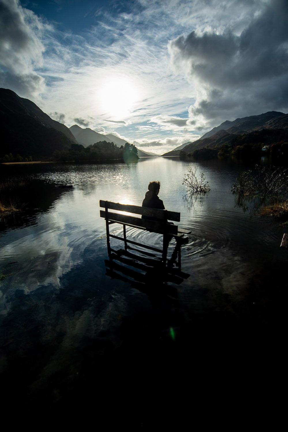 Woman on a park bench in shallow water