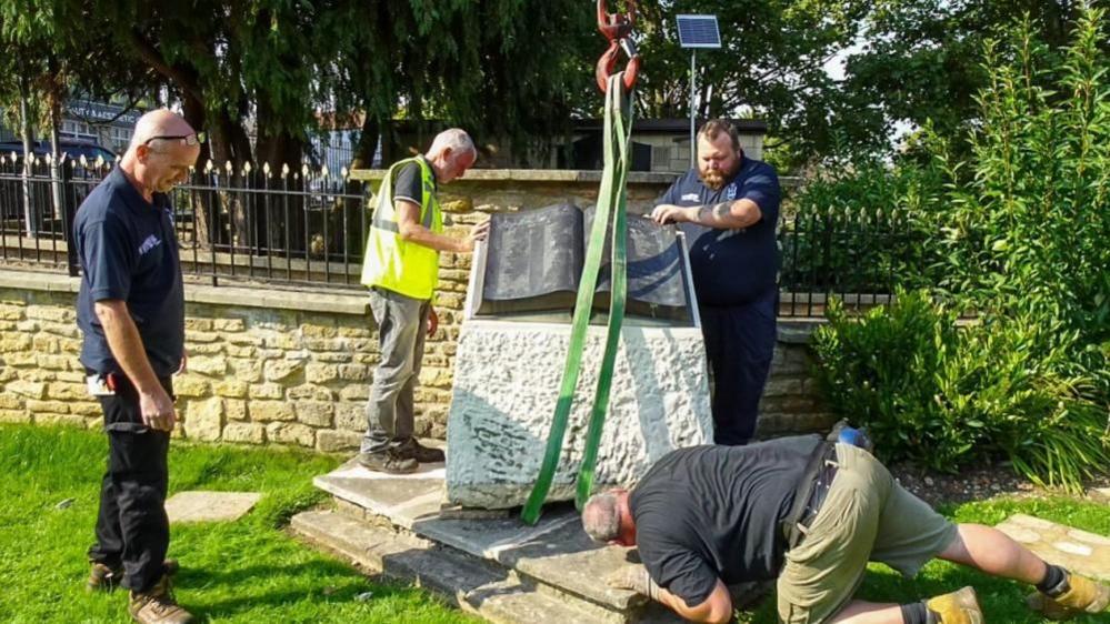 Melksham Town war memorial being placed by crane in the Queen Mary Garden as part of it's relocation.