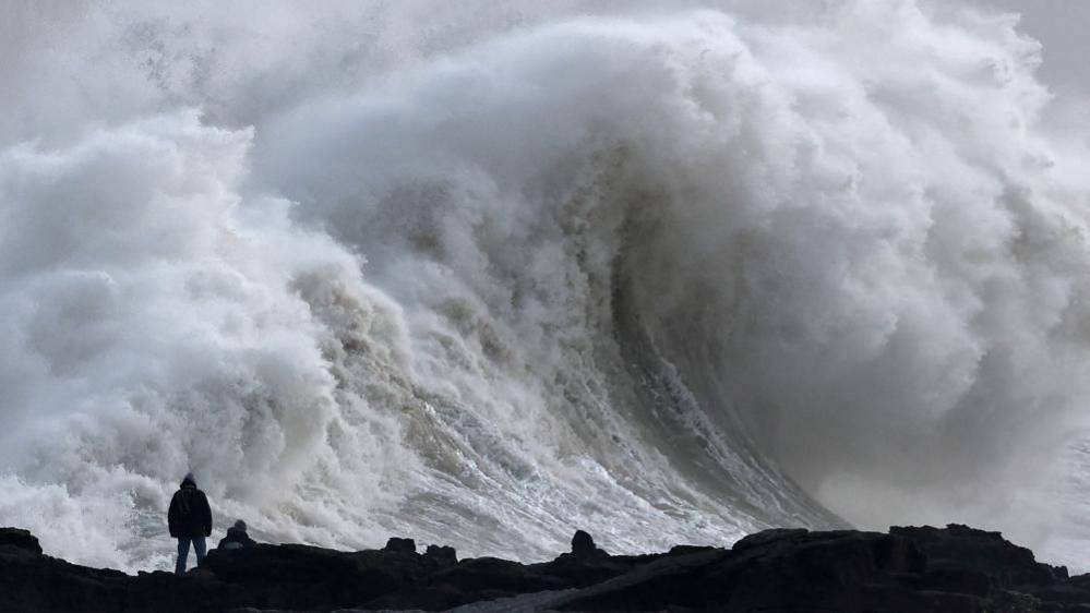 A person views large waves as Storm Eowyn arrives, in Porthcawl, Wales, 