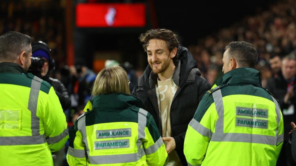 Man talking to three paramedics