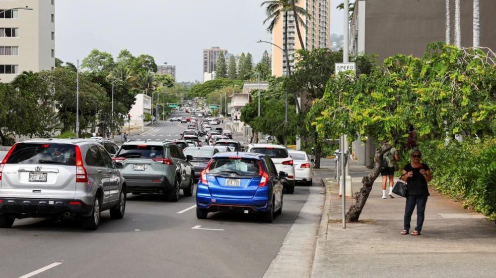 Long line of traffic in one direction, and no vehicles on the other side of the road.