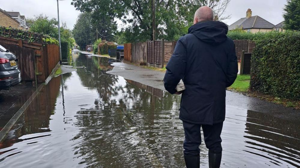 Rear of man standing in flood