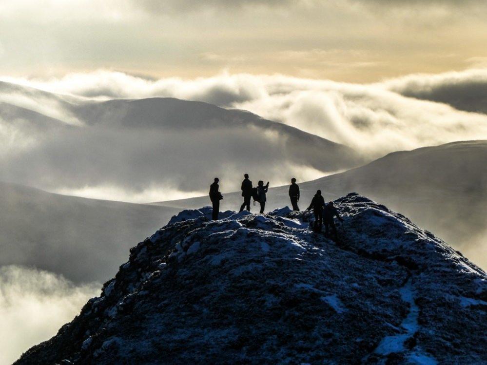 Figures at the top of a mountain