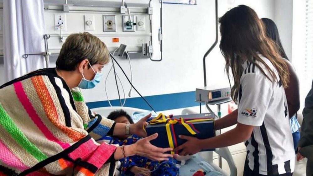 Colombian First Lady Veronica Alcocer (L) during her visit to the four siblings