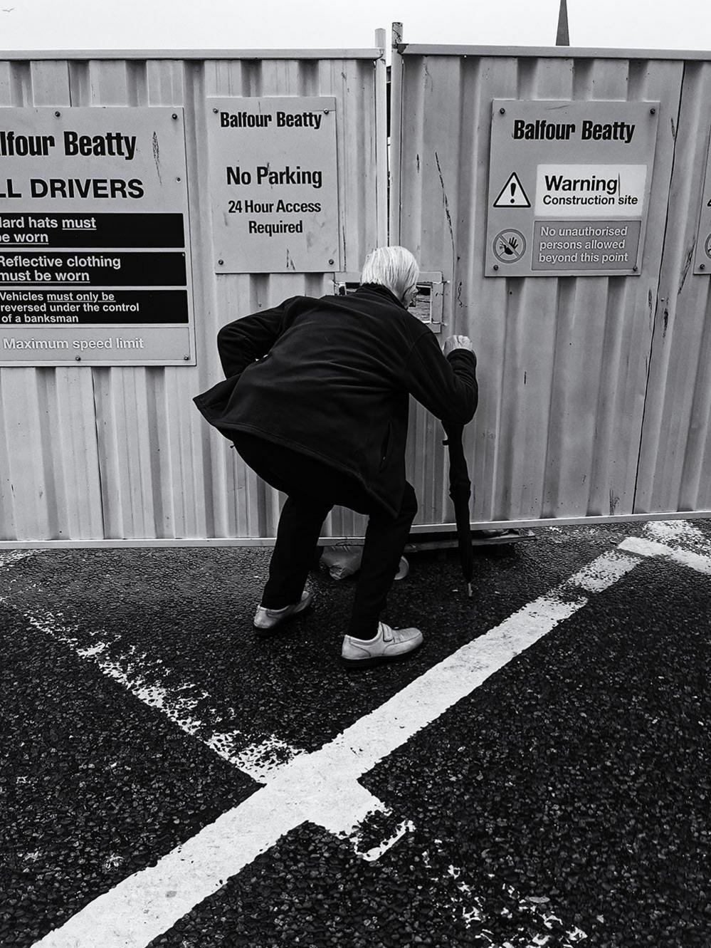 Man peeping through barriers