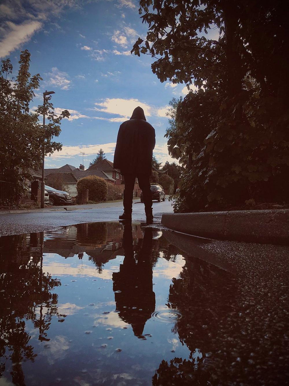 Man reflected in a puddle