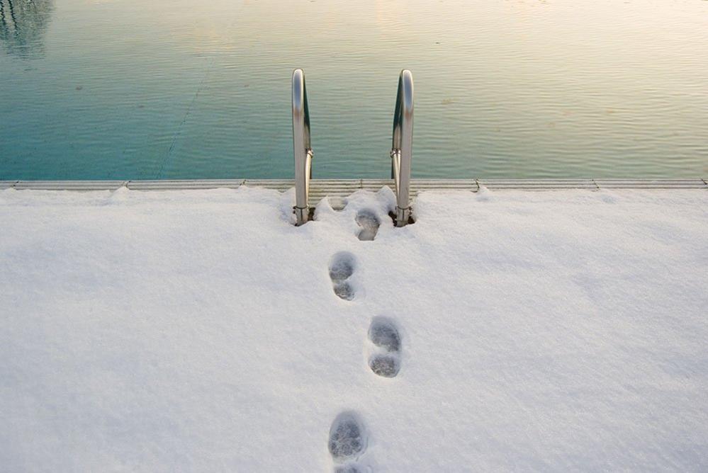 Footprints in the snow beside a swimming pool