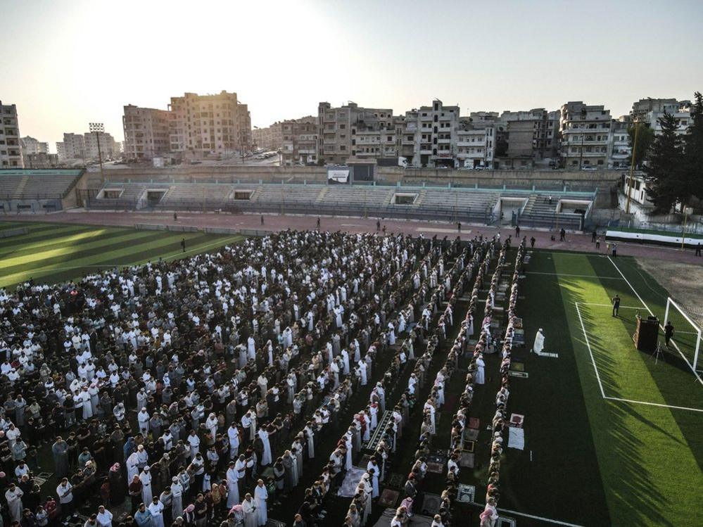 An aerial view shows Syrians displaced from their homes and have been living in tents due to the civil war performing Eid al-Adha prayers at a stadium in Idlib, Syria