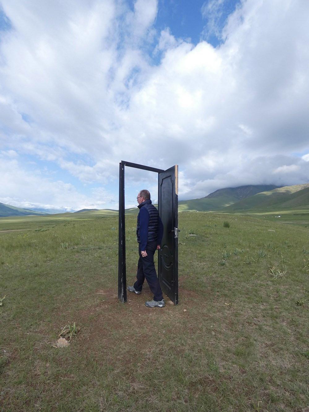 Man walking through door in a field