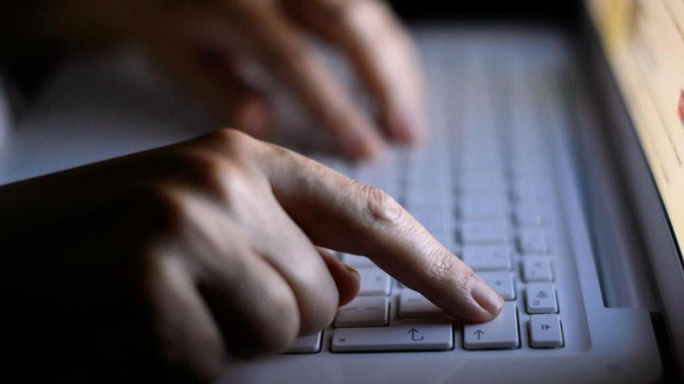 Person using a laptop computer keyboard