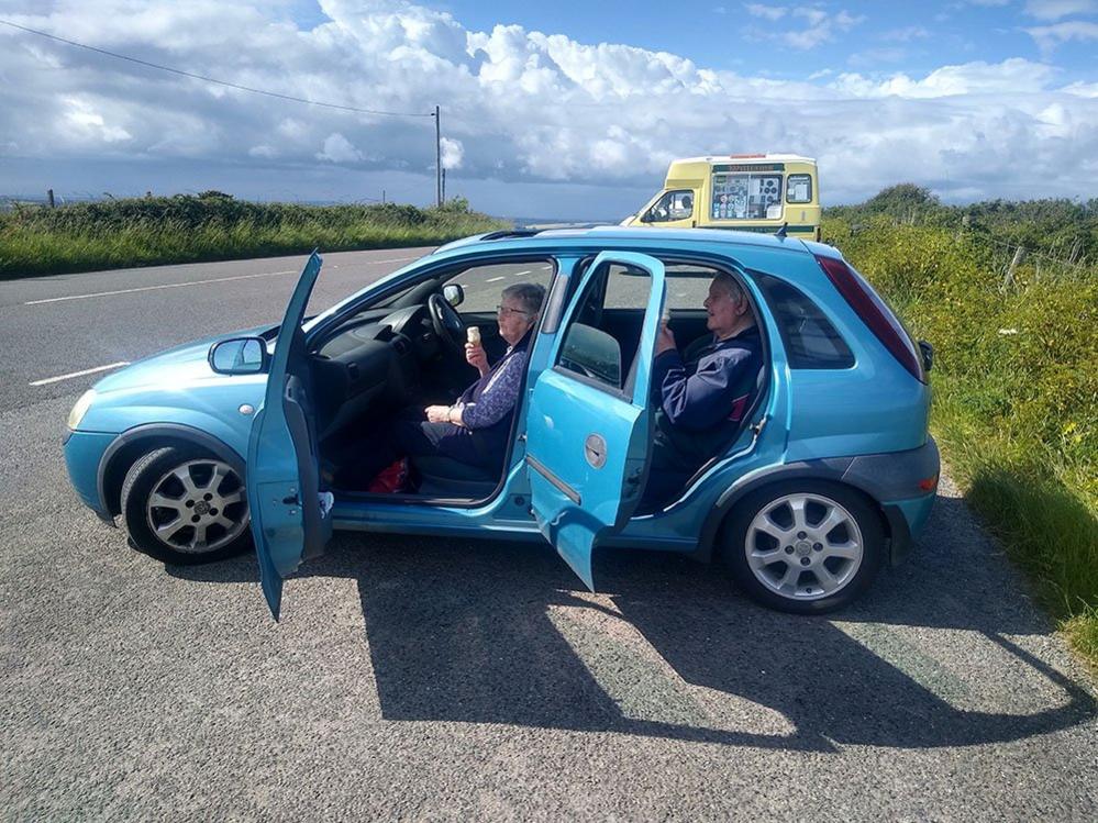 Two people eat ice cream in a car