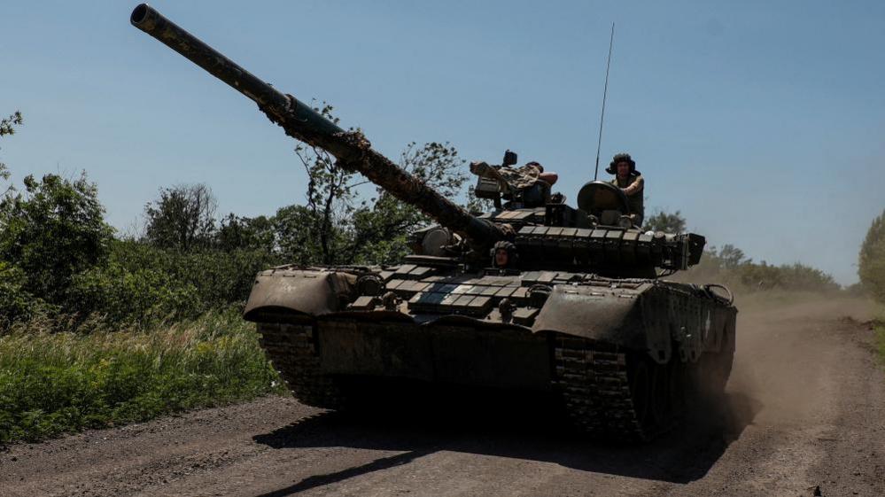 Ukrainian servicemen of the 30th Kostiantyn Ostrozkyi Separate Mechanised Brigade ride in a T-80 main battle tank captured earlier from Russian troops, along a road near the front line town of Bakhmut, amid Russia's attack on Ukraine, in Donetsk region, Ukraine, on 19 June 2023