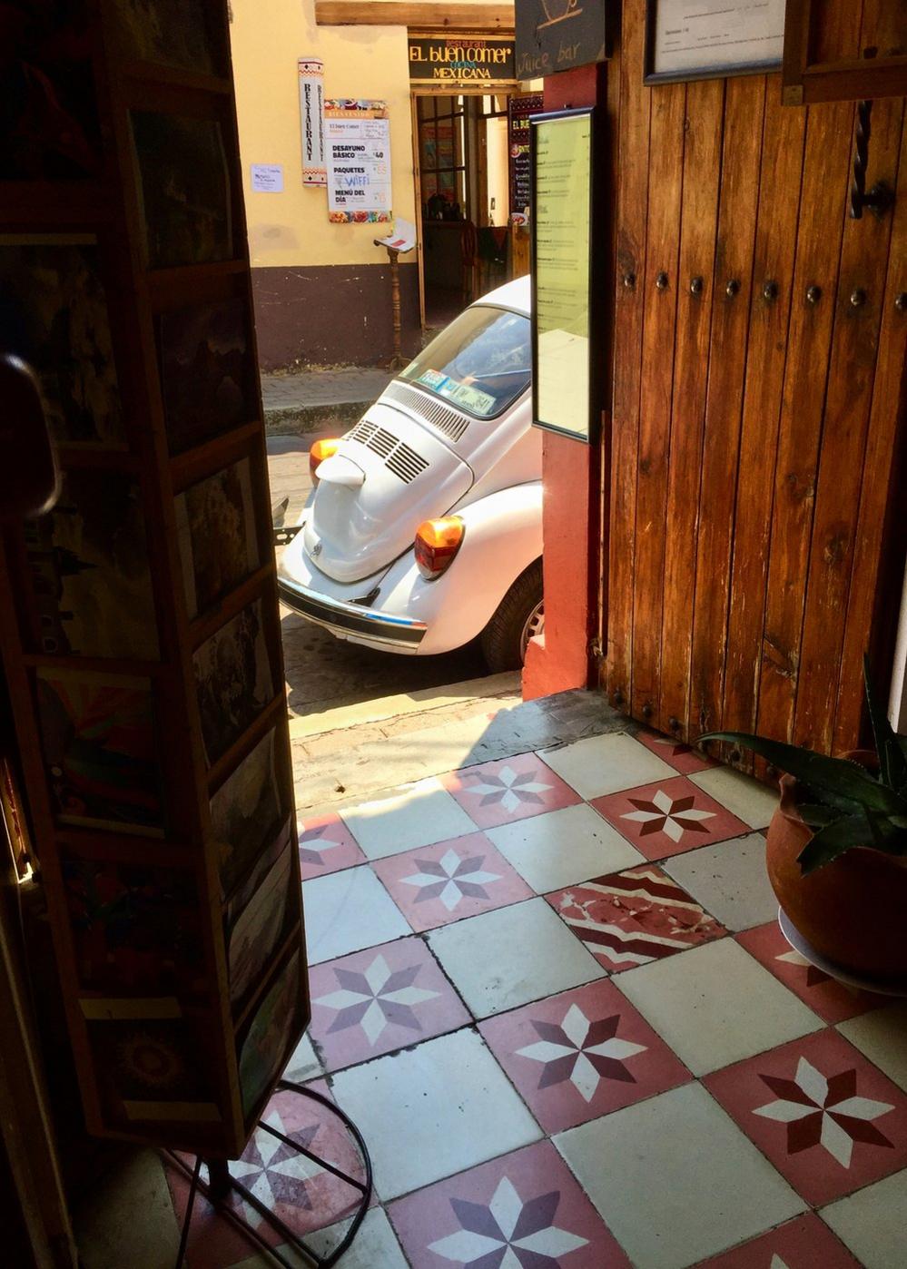 Volkswagen Beetle seen through a doorway from inside a building