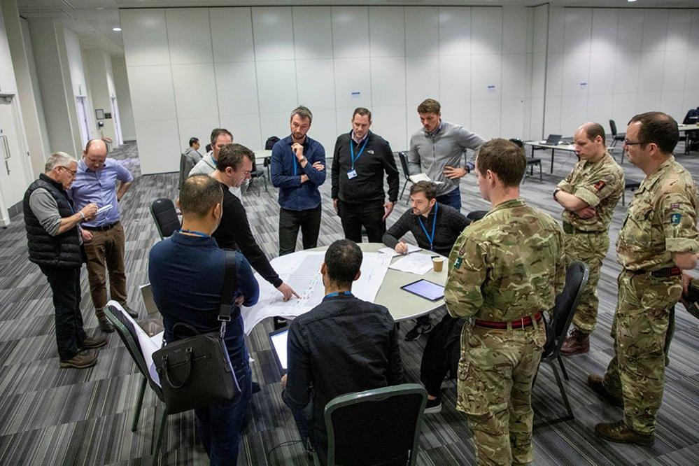 Different command elements gather as they plan the build of the hospital