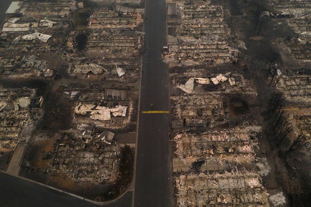 A person walks past gutted homes in the Medford, Oregon