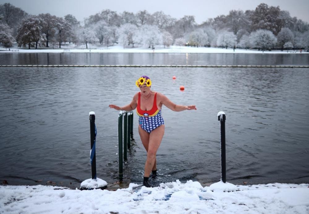 A swimmer dips her feet in Serpentine lake, in Hyde Park, London