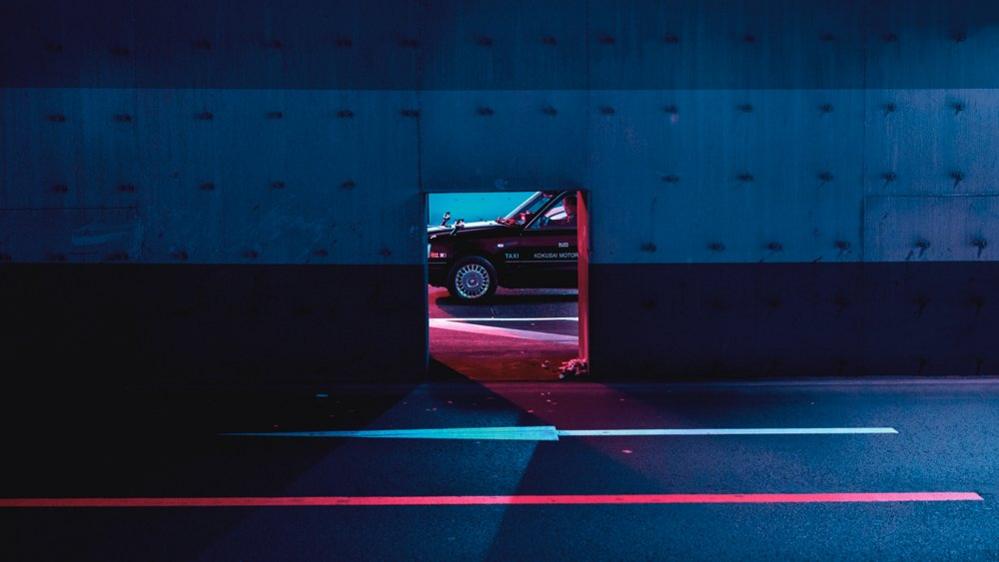 A car through the hole in a metal wall