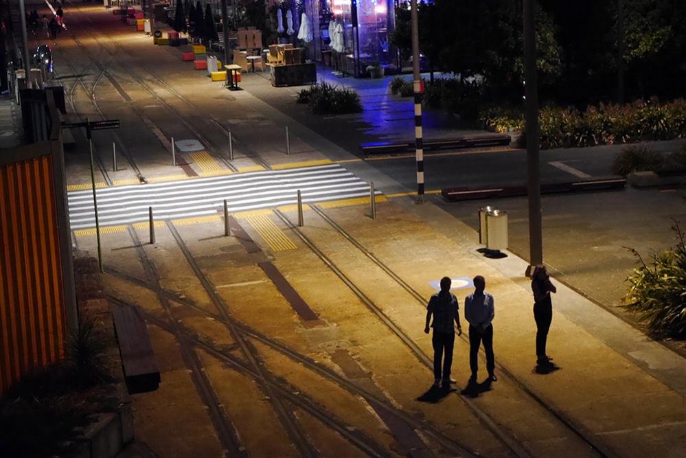 Two men and a woman stood on a street in Auckland, New Zealand