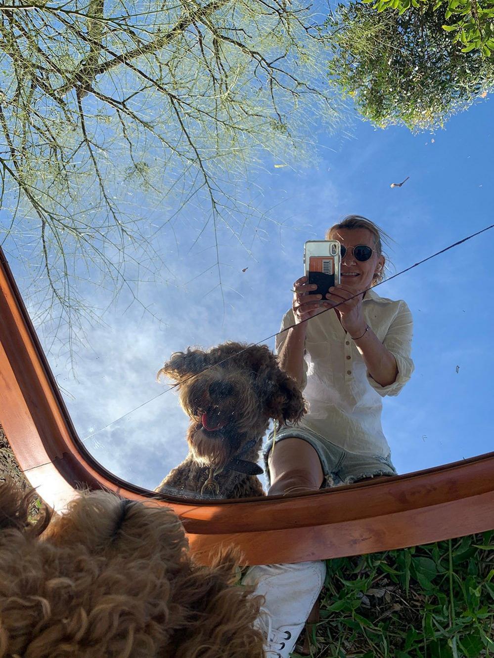 Woman and a dog reflected in a mirror