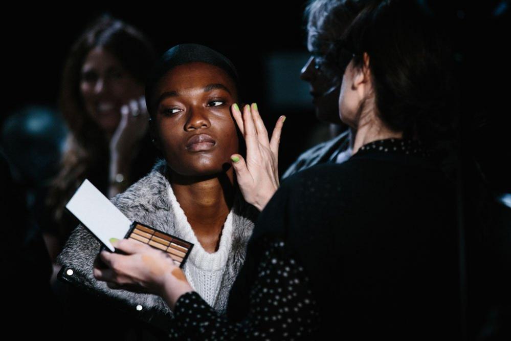 A model gets her make up done at the backstage before the Michael Kors Fashion