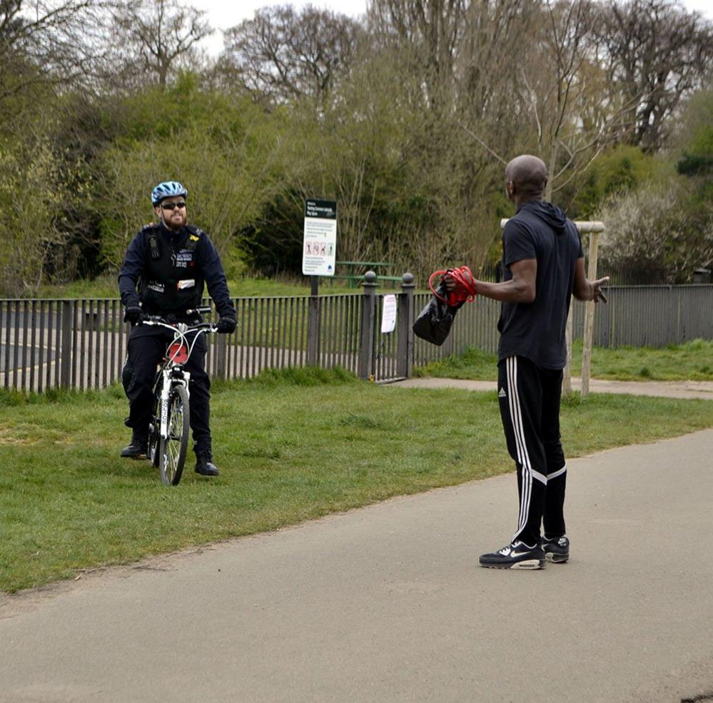 A policeman talking to a person in a park