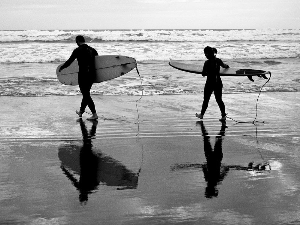 Surfers on Piha Beach, New Zealand