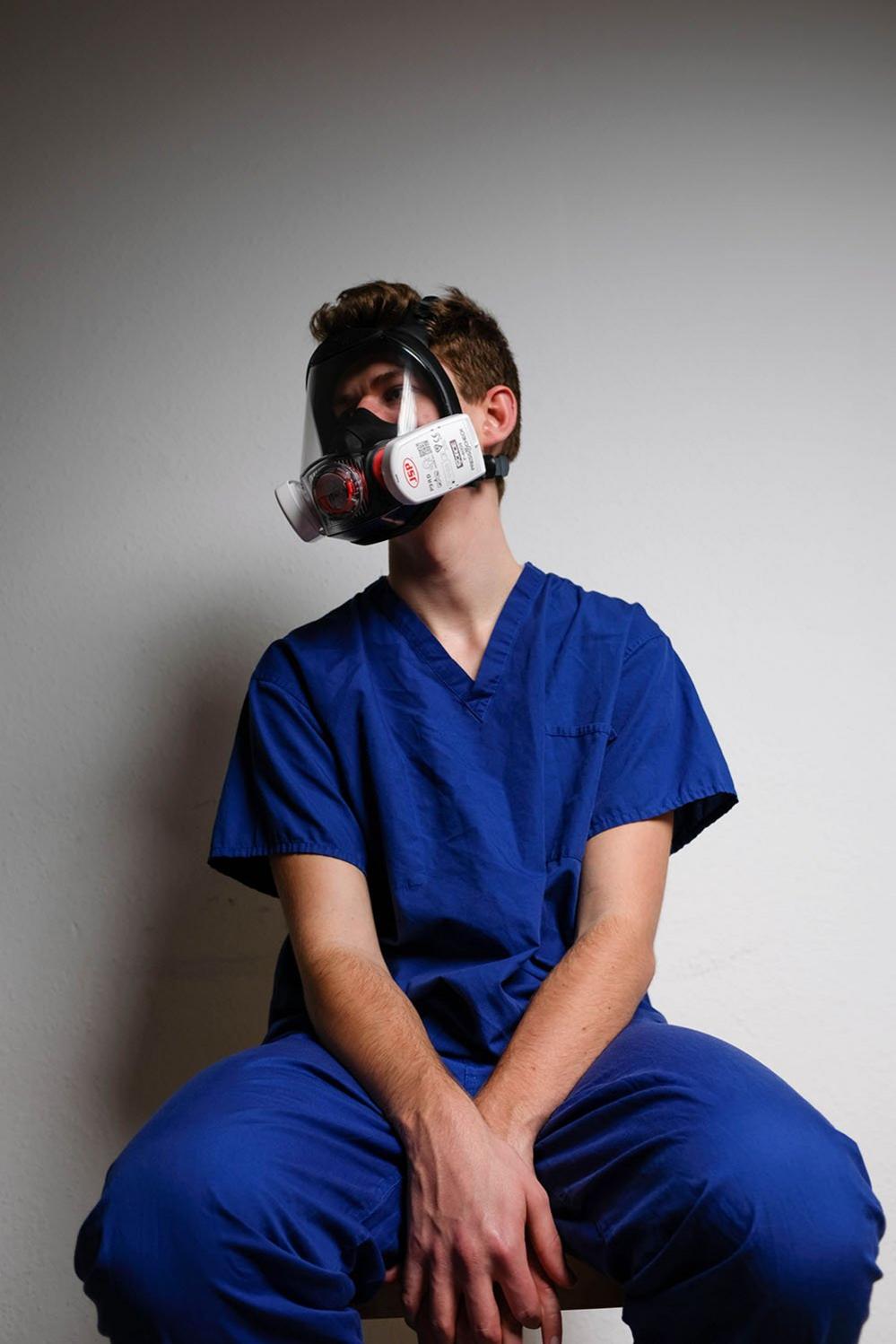 A junior doctor with face mask on at home