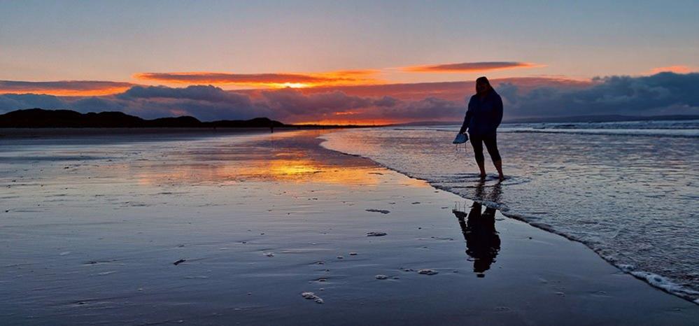 Figure on a beach at sunset