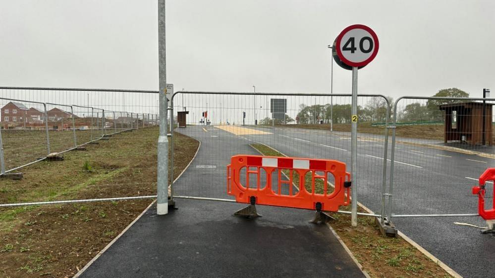 New unused road with red carriers across it