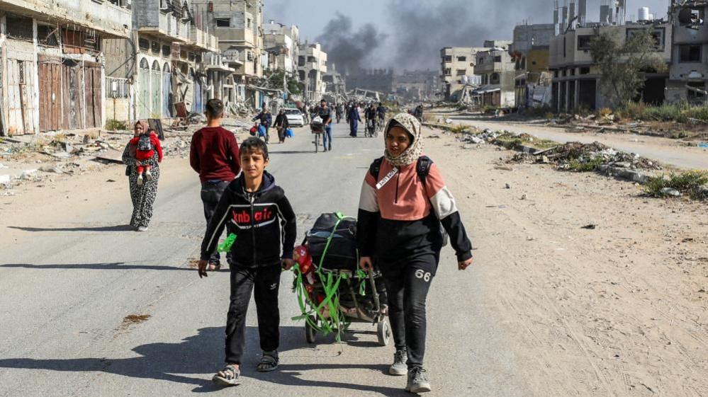 Displaced Palestinians walk along road in Gaza (file photo)
