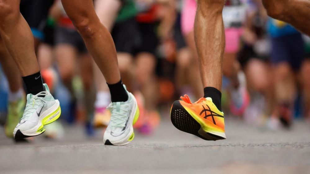 The feet and lower legs of two marathon runners