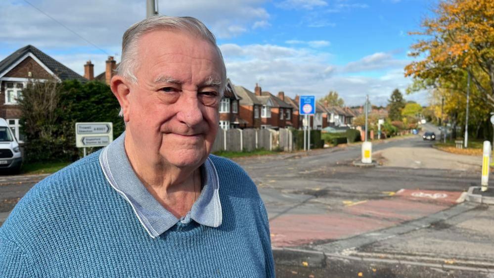 Mick Shirley, who lives near the junction, posing for a photo with the roundabout in the background.