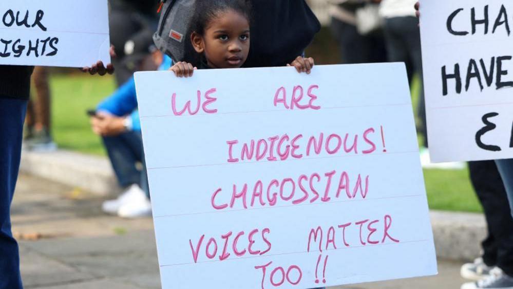 A child holding a placard