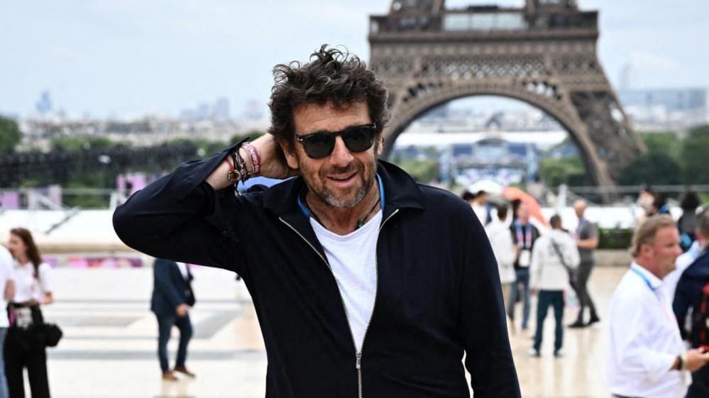 File pic showing Patrick Bruel in a black cardigan, black hair and a white T-shirt