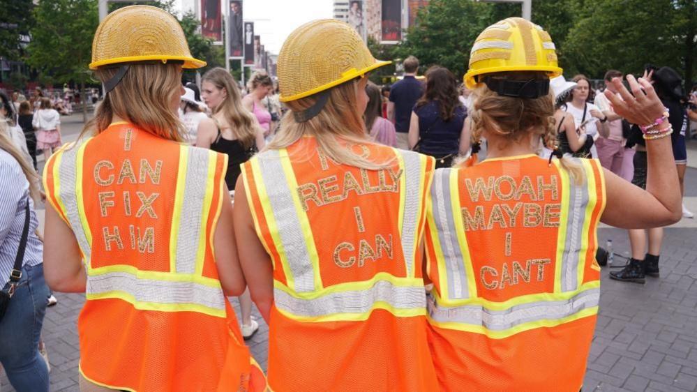 Rear view of three women wearing hi-vis jackets