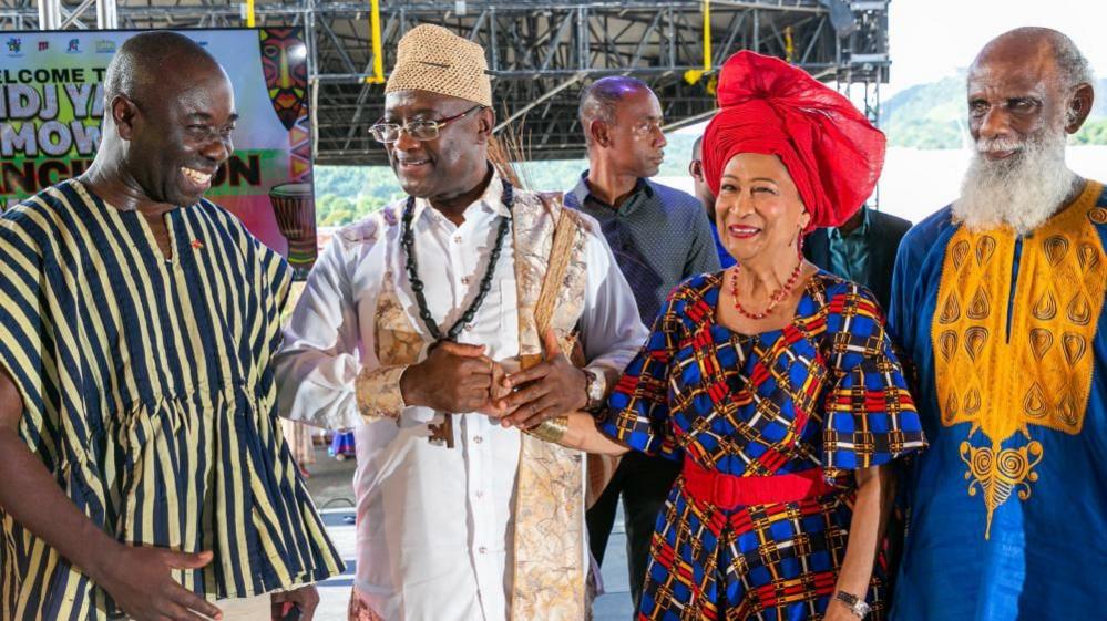 Prime Minister of Trinidad and Tobago, Kamla Persad-Bissessar dressed in Nigerian-inspired clothed stand with other dignitaries.
