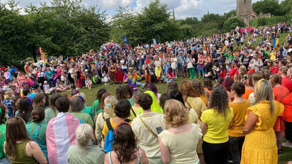 Crowd of people dressed in colourful outfits in a park