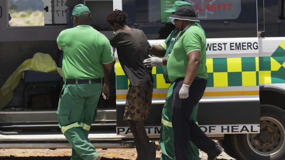 An emancipated miner is brought to a waiting ambulance after being rescued 